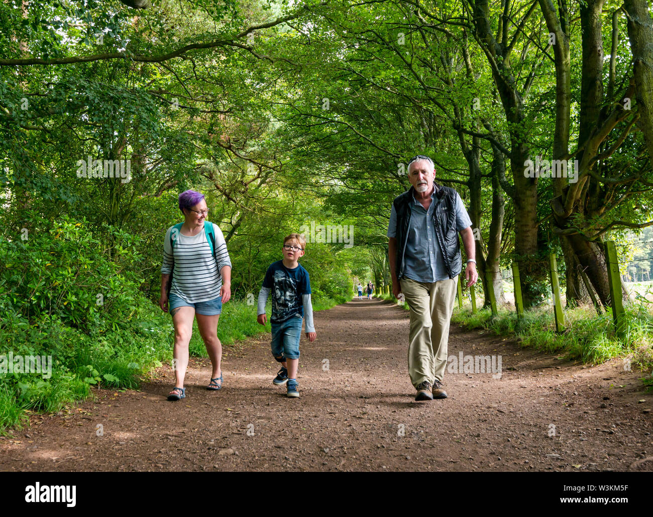 Three generation family walking avec grand-père, petit-fils, père et fille, mère et fils, Tyninghame, East Lothian, Scotland, UK Banque D'Images
