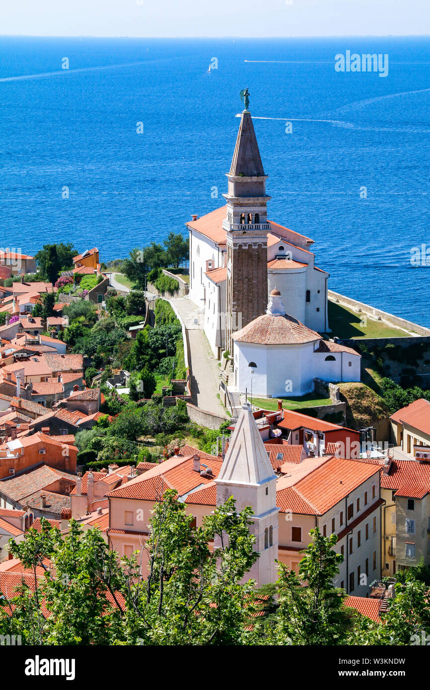 Vue sur St George's Church et le sol carrelé rouge toits de la vieille ville de Piran en Slovénie, avec la mer en arrière-plan Banque D'Images