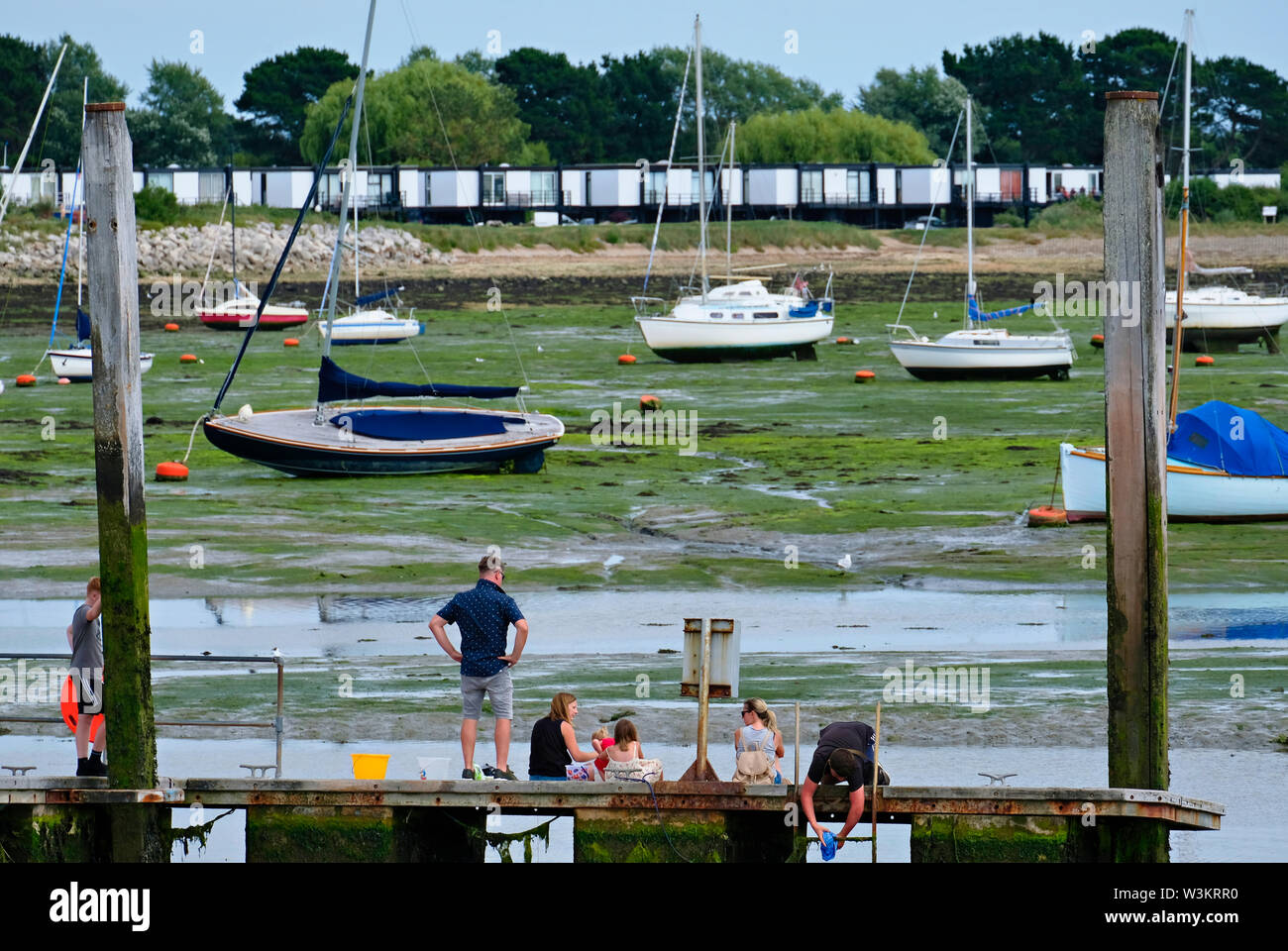 Emsworth Harbour, Hampshire, Royaume-Uni. Famille faire un pique-nique sur une jetée à marée basse Banque D'Images