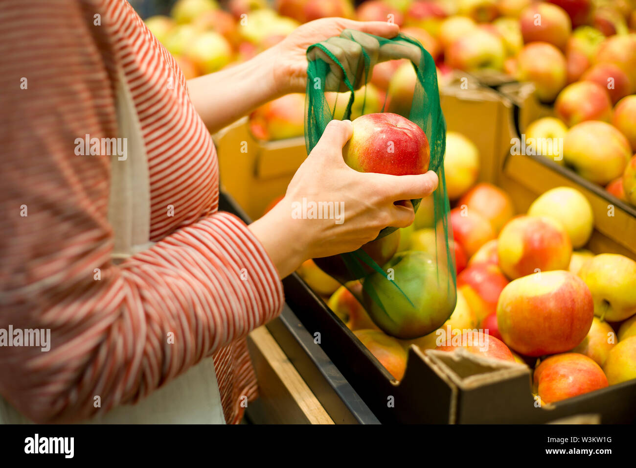 Une femme prend des fruits à un comptoir de magasin. Banque D'Images