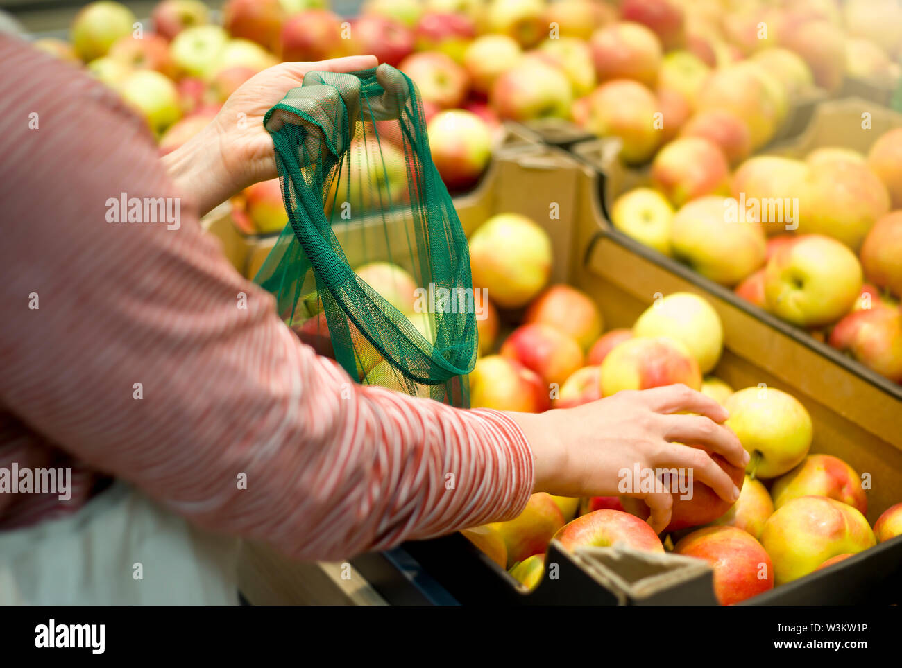 Une femme prend des fruits à un comptoir de magasin. Banque D'Images