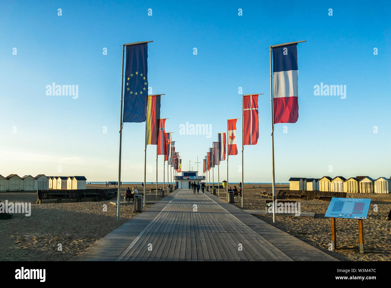 Promenade de la paix avec les drapeaux flottant à Riva Bella Beach, Ouistreham, Normandie, France. Banque D'Images