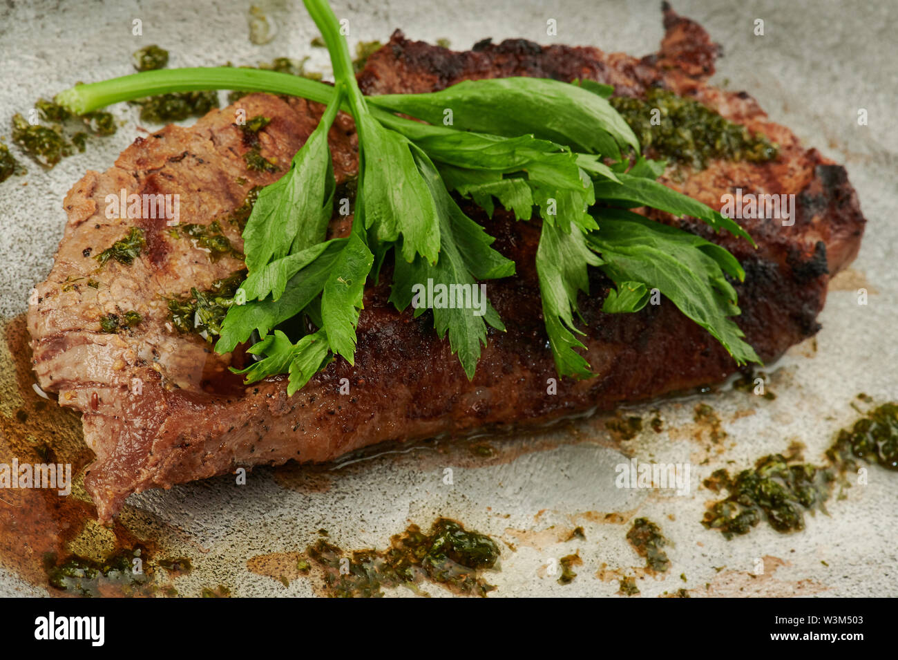 Gros morceau de viande grillée avec du persil vue rapprochée Banque D'Images