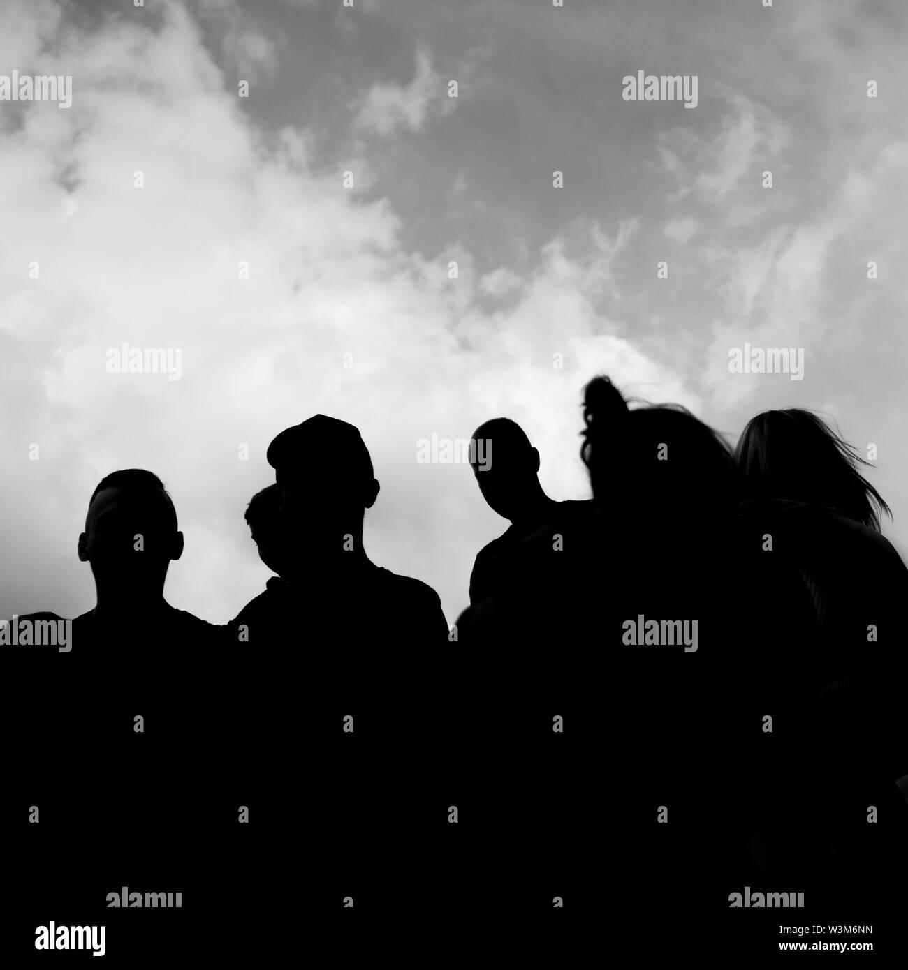 Une silhouette en noir et blanc d'un groupe de personnes avec ciel dans l'arrière-plan Banque D'Images