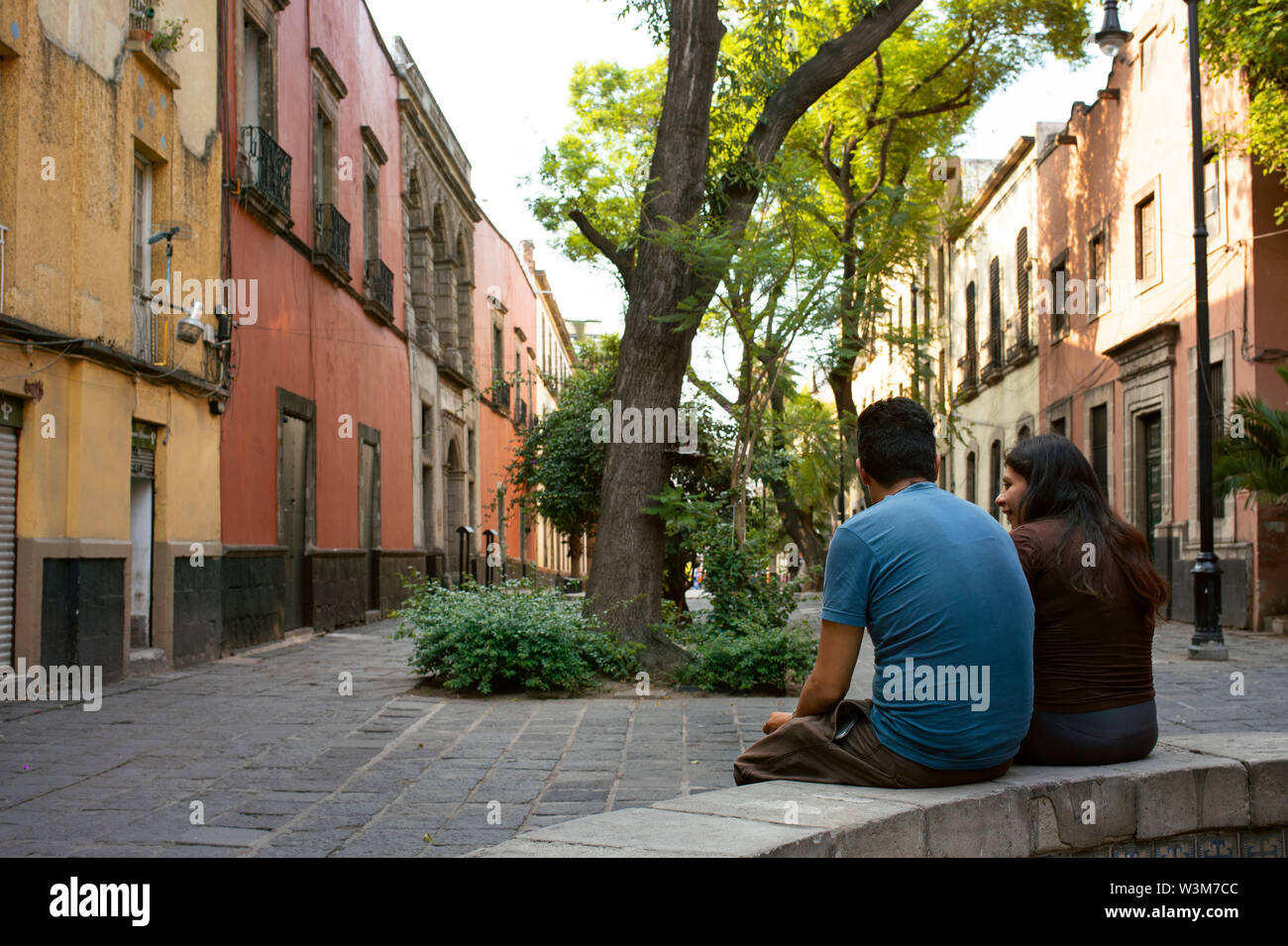 Scène de rue avec vue arrière du couple s'entretenir par la fontaine derrière la Plaza de Santo Domingo, Mexico, Mexique. Jun 2019 Banque D'Images