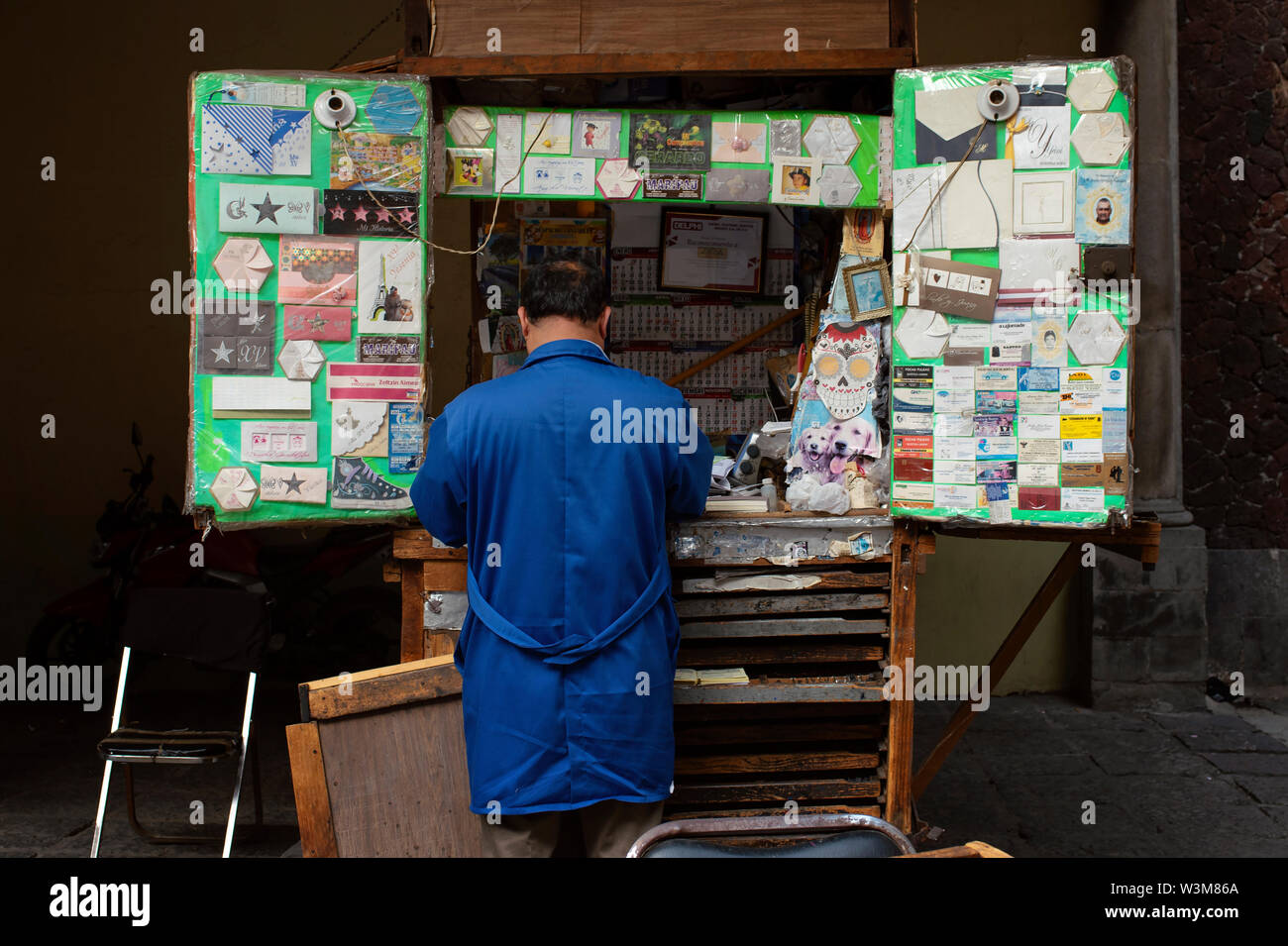 Vue arrière de l'homme locaux vendant des cartes de vœux pour différentes occasions à un kiosque traditionnel. Plaza de Santo Domingo, Mexico, Mexique. Jun 2019 Banque D'Images