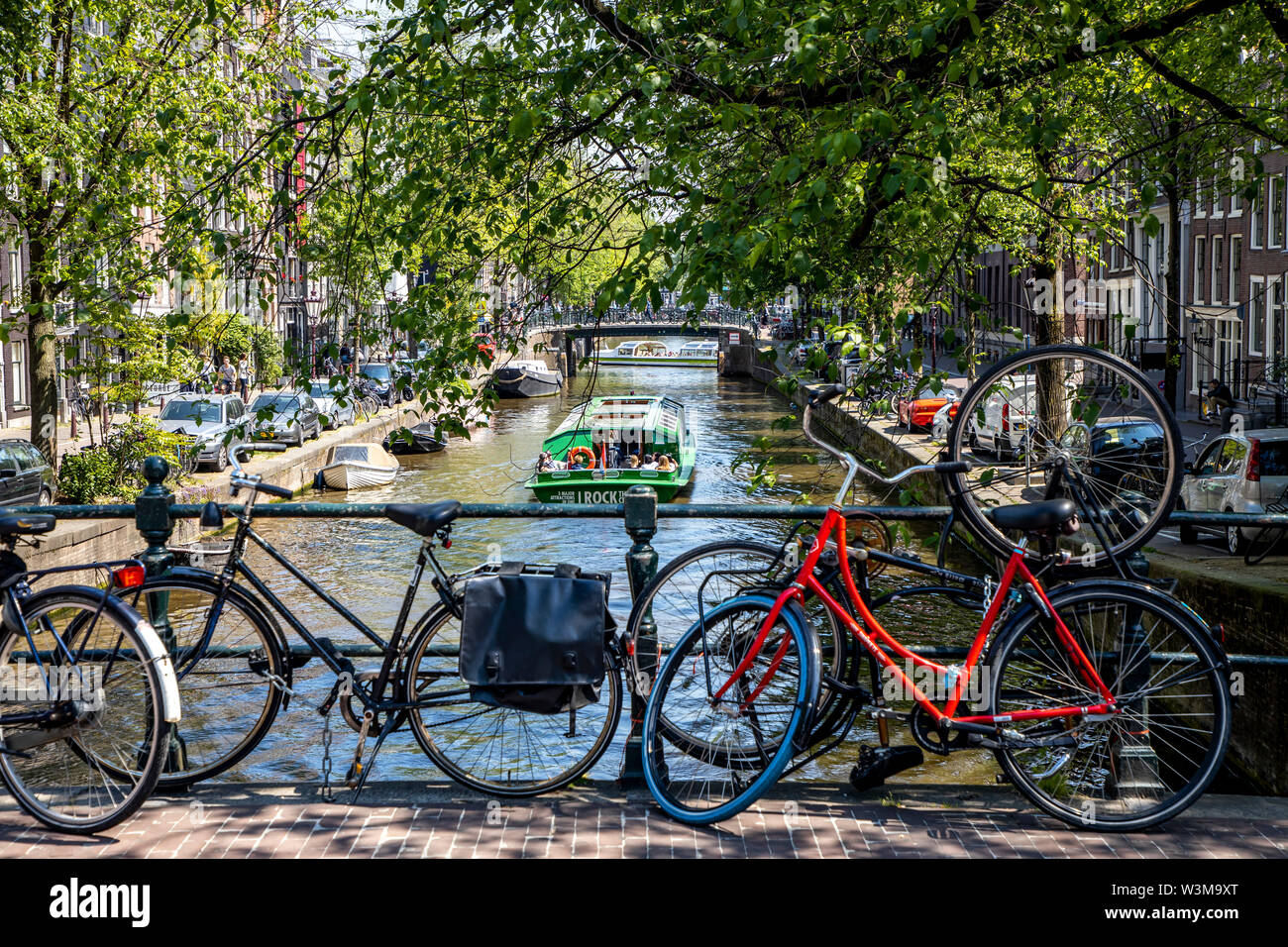 Amsterdam, Pays-Bas, le centre-ville, vieille ville, roues, stationné sur une balustrade d'un pont sur un canal, Banque D'Images