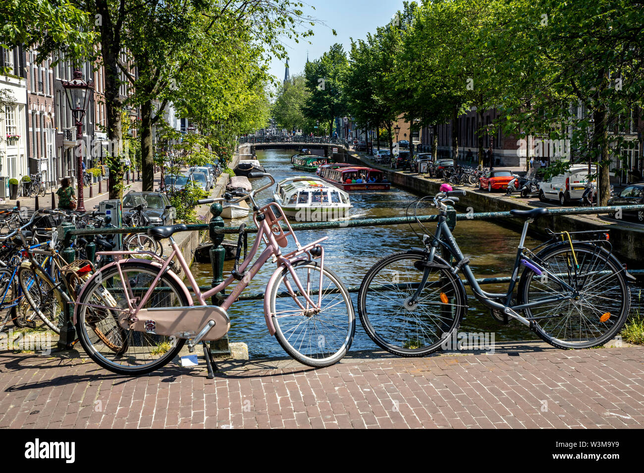 Amsterdam, Pays-Bas, le centre-ville, vieille ville, roues, stationné sur une balustrade d'un pont sur un canal, Banque D'Images