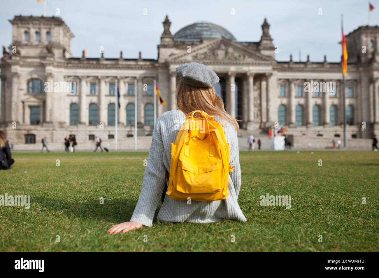 Jeune femme assise dans le parc par le Reichstag à Berlin, Allemagne Banque D'Images