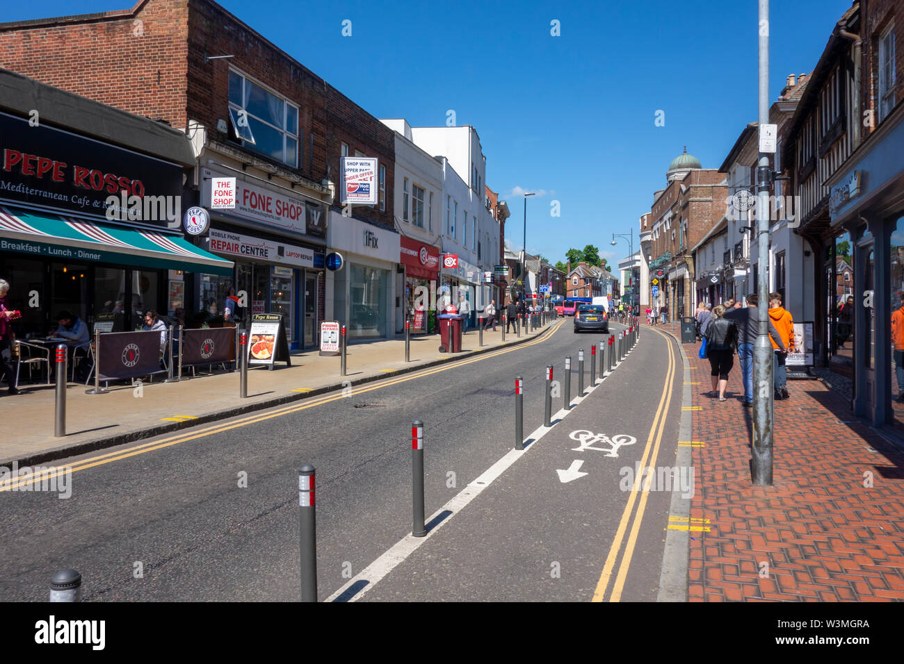 Voie cyclable, route, voitures et commerces sur High Street, Watford, Hertfordshire, Royaume-Uni Banque D'Images