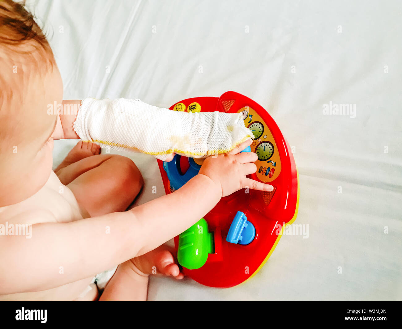 Valence, Espagne - juin 6, 2019 : Un bébé jouant à un hôpital avec son bras bandé avec du plâtre après un accident domestique Banque D'Images