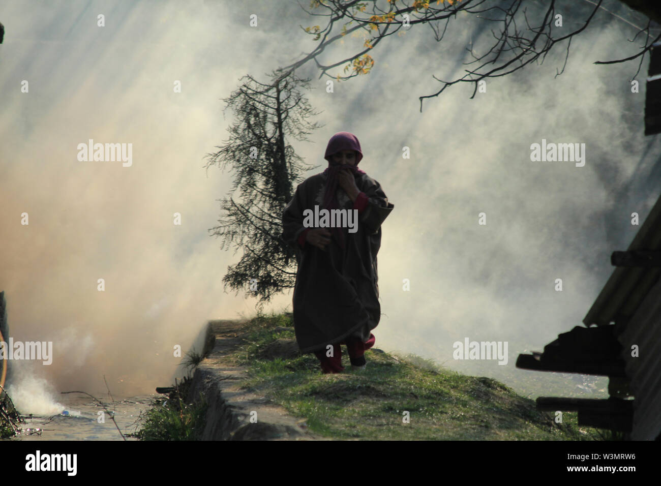 Une femme musulmane du Cachemire s'exécuter après la police indienne teargassed les funérailles de Zubair Turay un rebelle local qui était tué dans une rencontre avec les forces indiennes au Cachemire au sud du village de Drugad sur 01-2018 Avril ainsi que sept autres rebelles. Banque D'Images