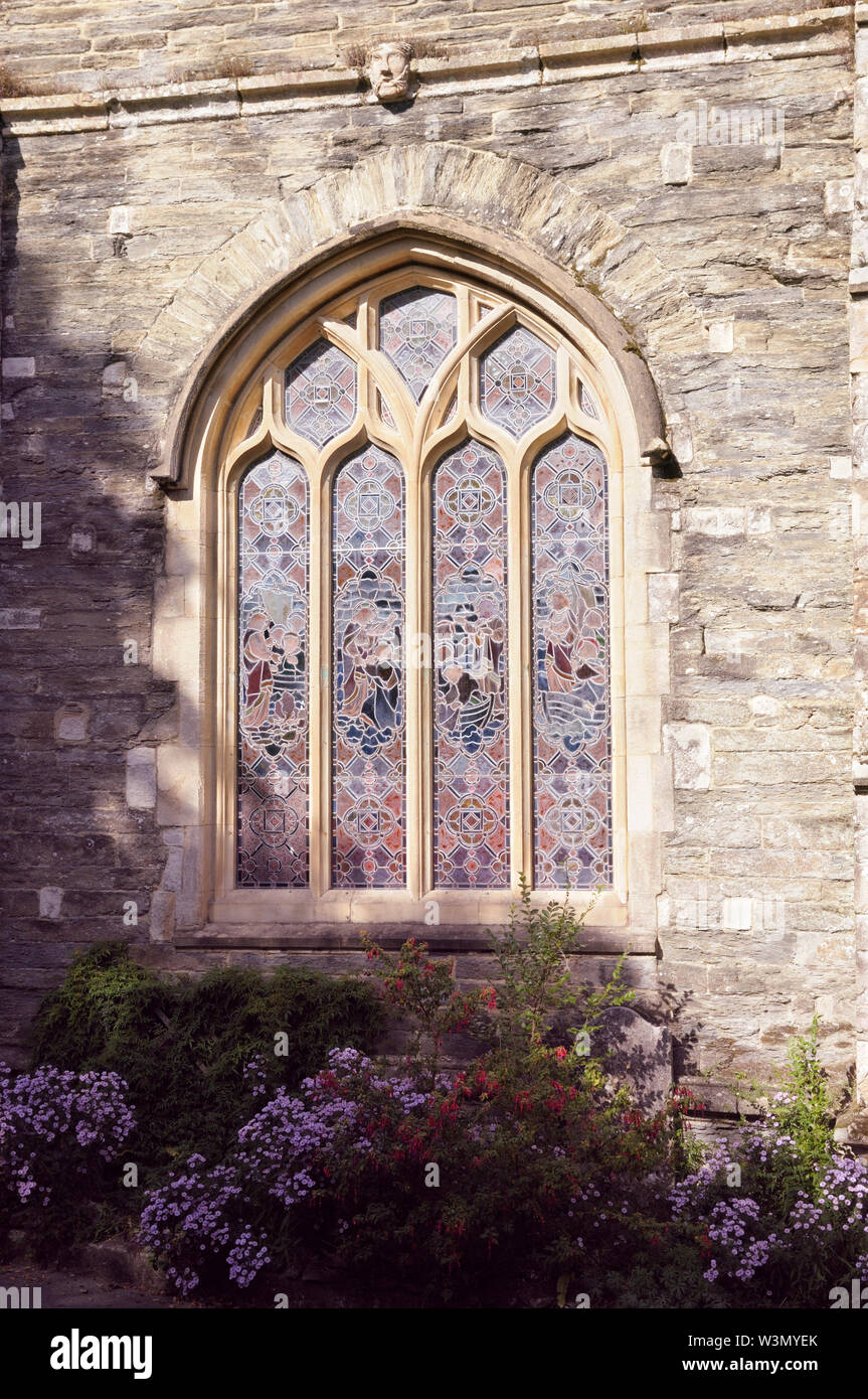 Vitrail avec sculpture remplages sur l'extérieur des murs en pierre d'une église. Banque D'Images