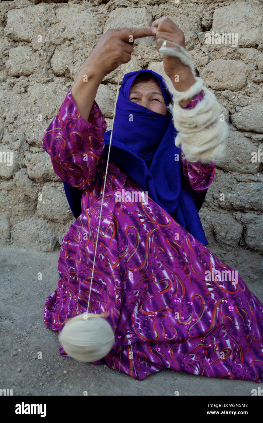Une femme de la communauté Hazara ethnique pour le tissage de laine vents pulls, à Maslakh camp pour personnes déplacées, à la périphérie nord-ouest de la ville de Herat. Le camp de Maslakh n'est plus officiellement en opération, mais beaucoup de gens de provinces reculées toujours chercher refuge ici, fuyant la pauvreté et les conflits dans les zones rurales. L'Afghanistan. 20 juin 2007. Banque D'Images