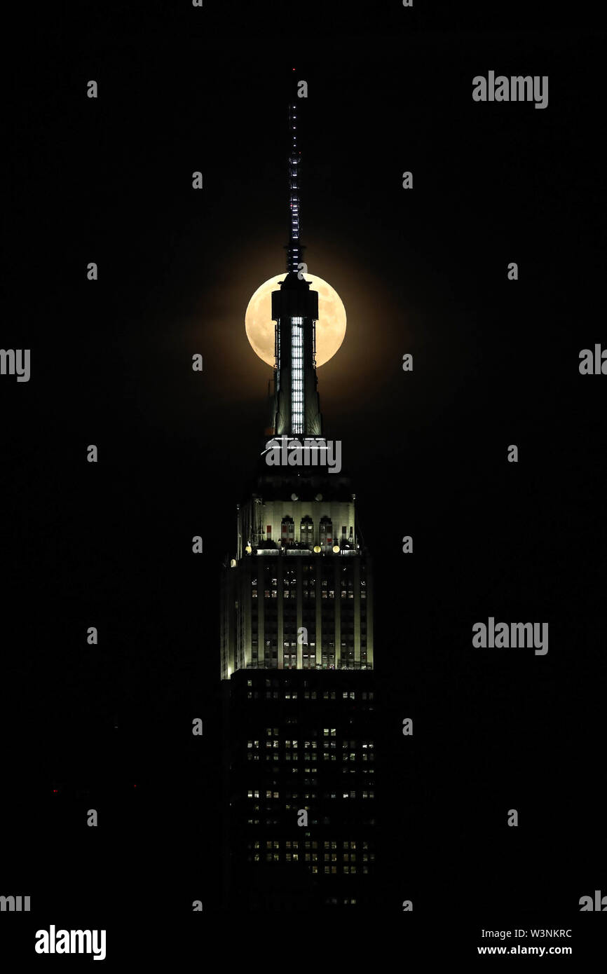 Hoboken, United States. 16 juillet, 2019. Pleine lune est vu près de Empire State Building à New York, de la ville de Hoboken, dans le New Jersey la nuit mardi, 16. Aujourd'hui célèbre 50 ans que Neil Amstrong, le premier homme qui a marché sur la lune. (PHOTO : WILLIAM VOLCOV/BRÉSIL PHOTO PRESSE) Credit : Brésil Photo Presse/Alamy Live News Banque D'Images