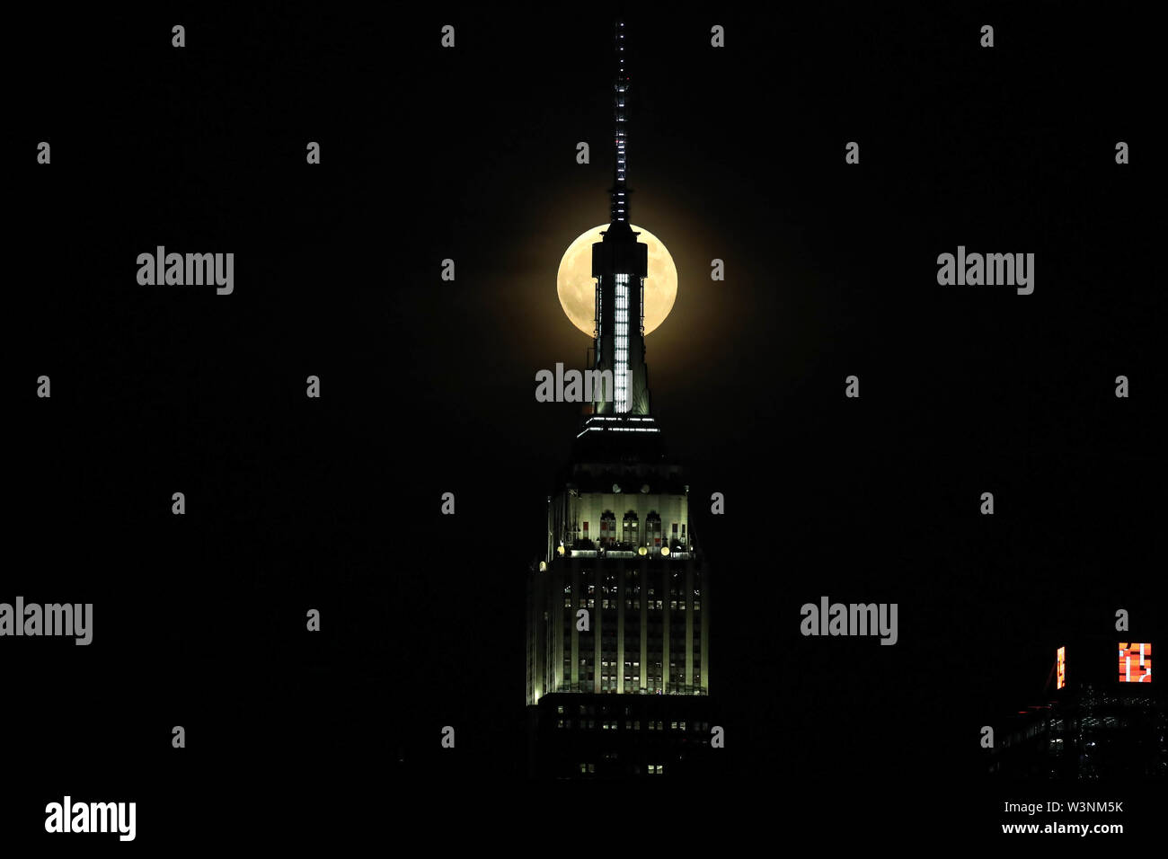 Hoboken, New Jersey, USA. 16 juillet, 2019. Pleine lune est vu près de Empire State Building à New York, de la ville de Hoboken, dans le New Jersey la nuit mardi, 16. Aujourd'hui célèbre 50 ans que Neil Amstrong, le premier homme qui a marché sur la lune. Crédit : William Volcov/ZUMA/Alamy Fil Live News Banque D'Images