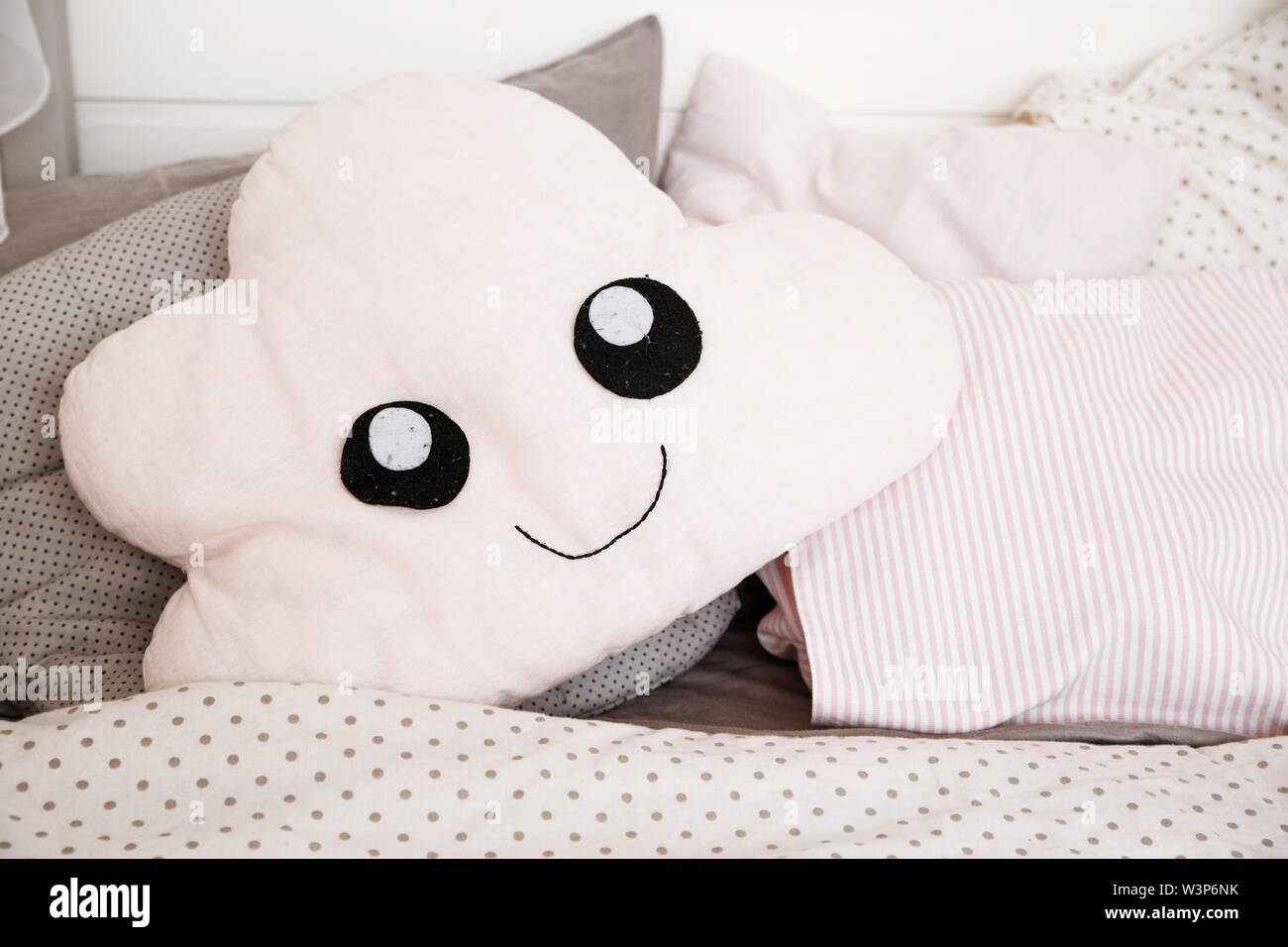 Un oreiller en forme de nuage se trouve sur un lit d'enfants Photo Stock -  Alamy