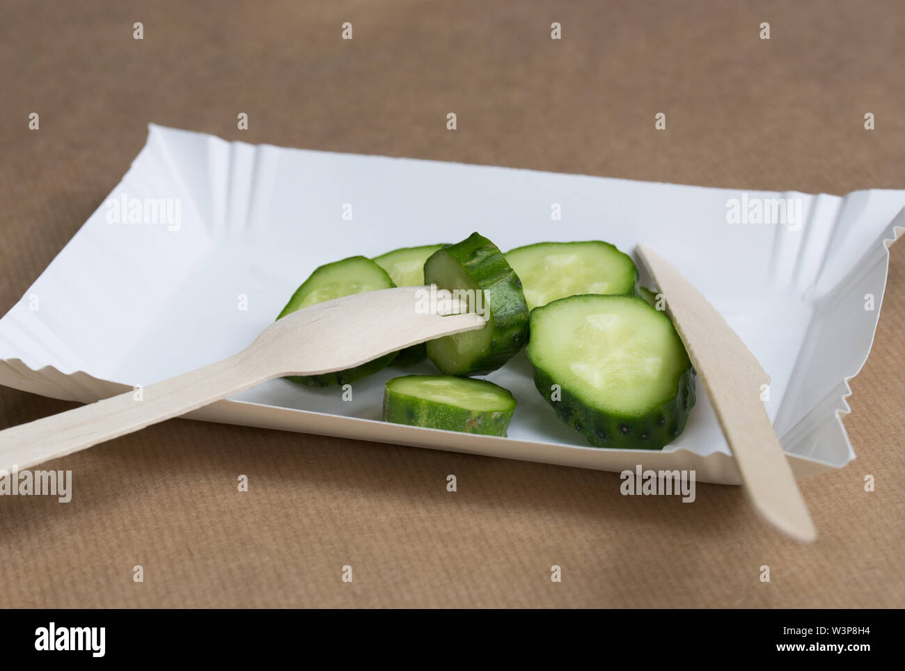 Papier écologique palte et couverts en bois avec des tranches de concombres Banque D'Images