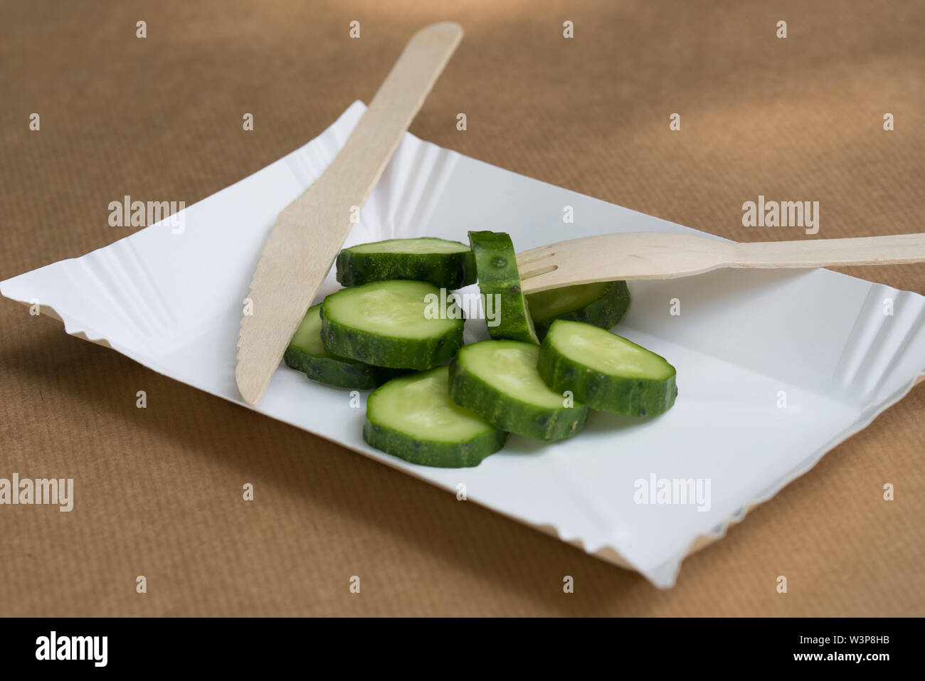 Papier écologique palte et couverts en bois avec des tranches de concombres Banque D'Images