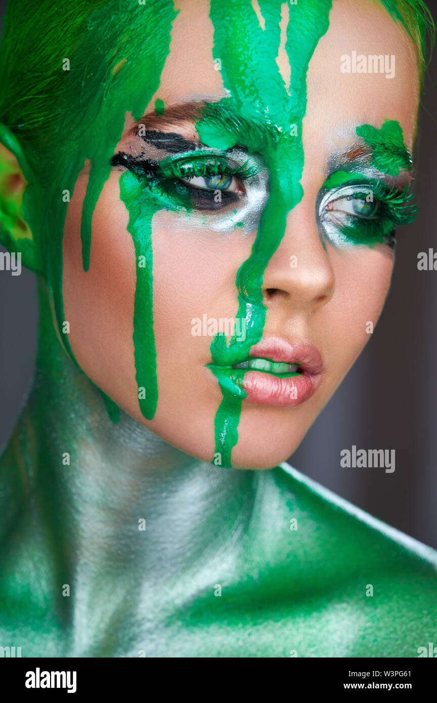 Modèle de haute couture. Une femme exceptionnelle avec un miroir métallique vert néon vert qui fuit et la peinture. Vivid Pink makeup Banque D'Images