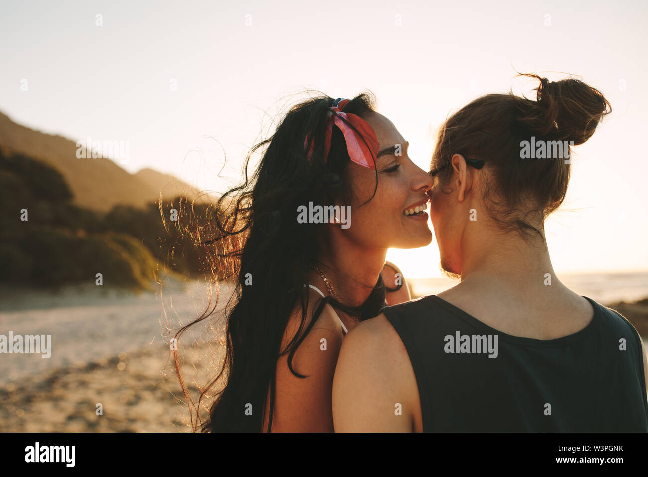 Woman whispering mots d'amour dans l'oreille de son petit ami. Beau couple de passer du temps ensemble sur leurs vacances d'été. Banque D'Images