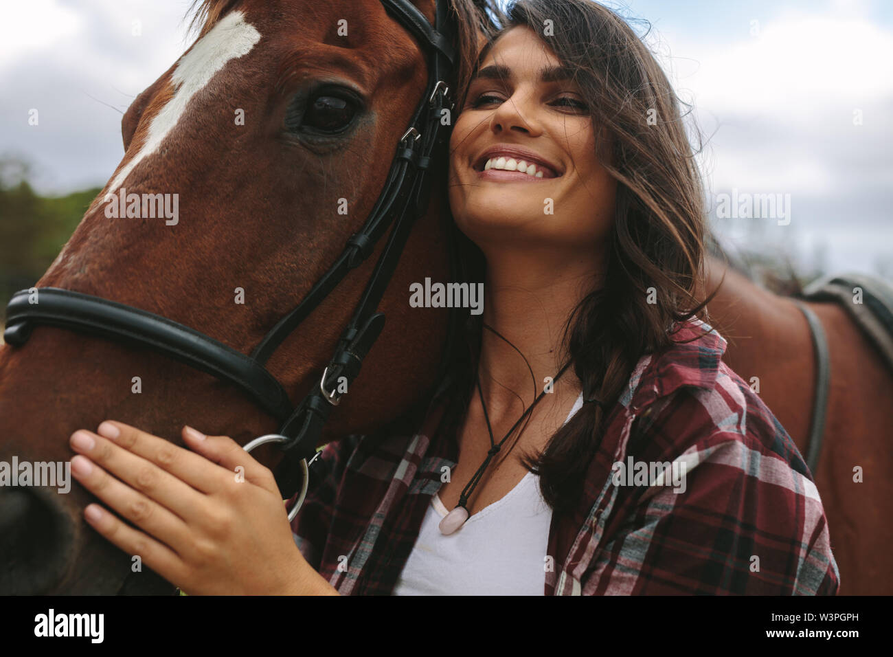 Close up of young woman hugging son cheval. Cowgirl aimant son cheval à l'extérieur. Banque D'Images
