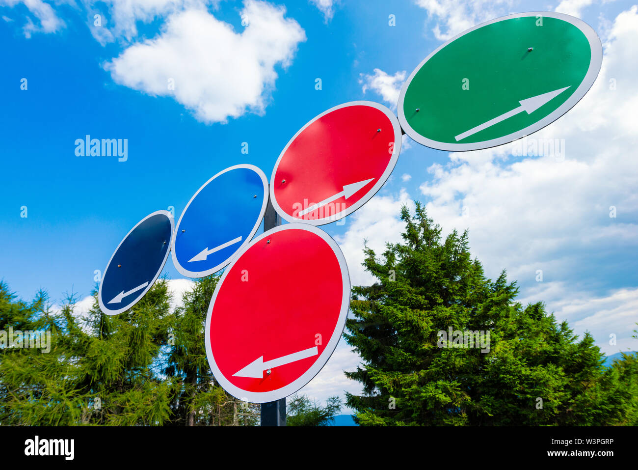 Des signes de choix - des signes circulaires avec des flèches blanches avec espace pour content contre le ciel bleu Banque D'Images