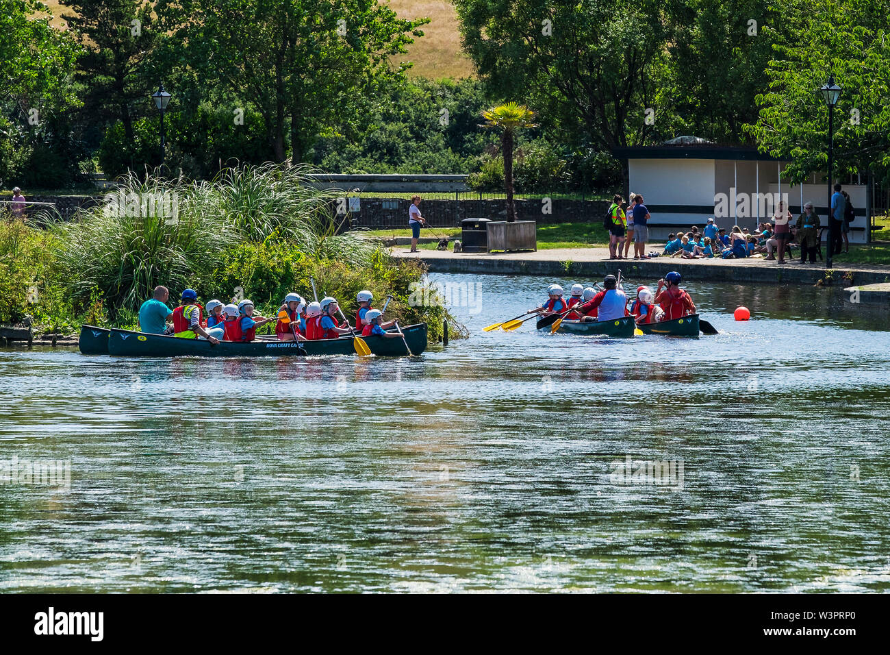 Les élèves de l'école primaire bénéficiant d'une activité de plein air comme leçon qu'ils ont plaisir à canot sur le lac de plaisance Jardin Trenance à Newquay en Cornouailles. Banque D'Images