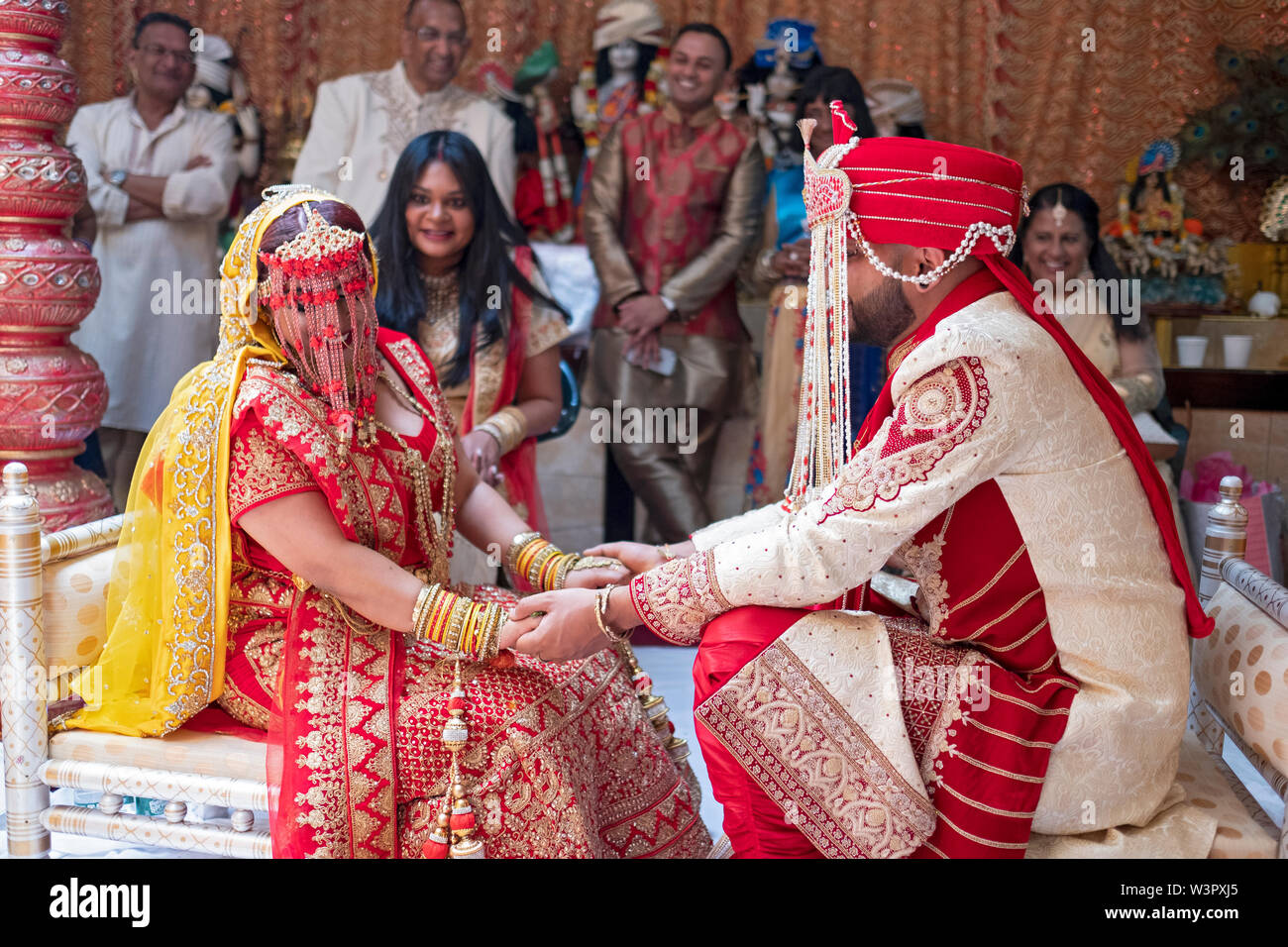 Une femme et un homme tenir la main au cours d'une cérémonie de mariage traditionnelle hindoue dans un temple à Ozone Park, Queens, New York. Banque D'Images