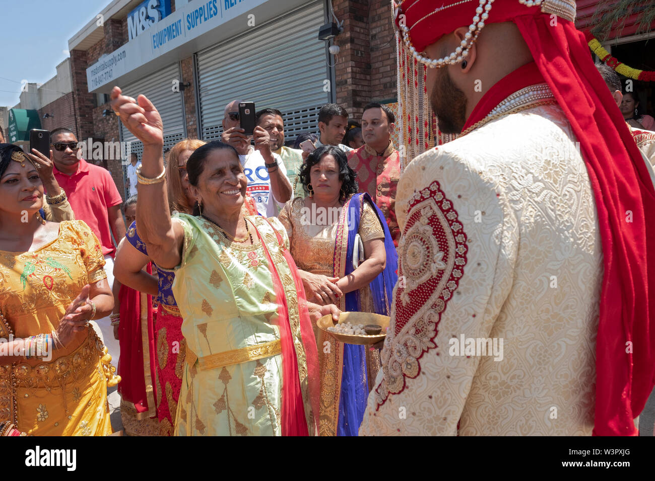 Lors d'une cérémonie de mariage traditionnelle hindoue le marié est accueilli par la grand-mère de la mariée avant d'entrer dans le temple. à Ozone Park, Queens, NY Banque D'Images