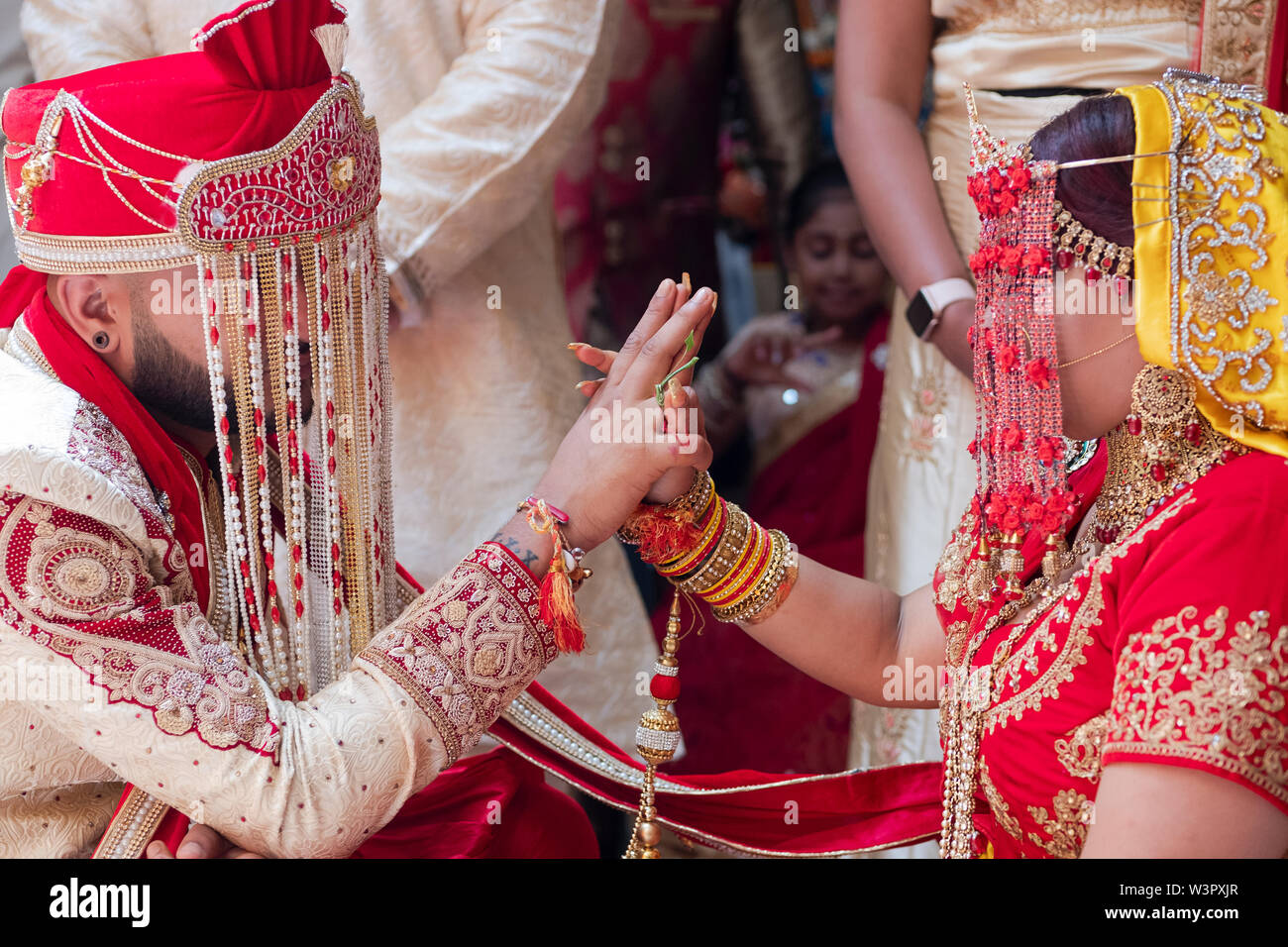 Une jeune mariée et se toilettent touch mains au cours d'une cérémonie de mariage hindou traditionnel Shakti dans un temple à Ozone Park, Queens, New York City Banque D'Images