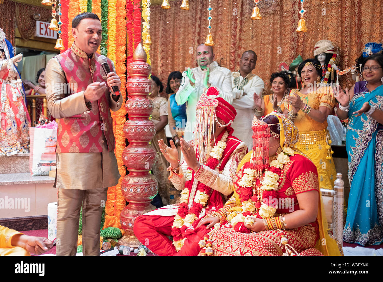 Près de la fin d'un mariage hindou traditionnel l'oncle de la mariée fait un discours qui attire les applaudissements. En Ozone Park, Queens, New York. Banque D'Images