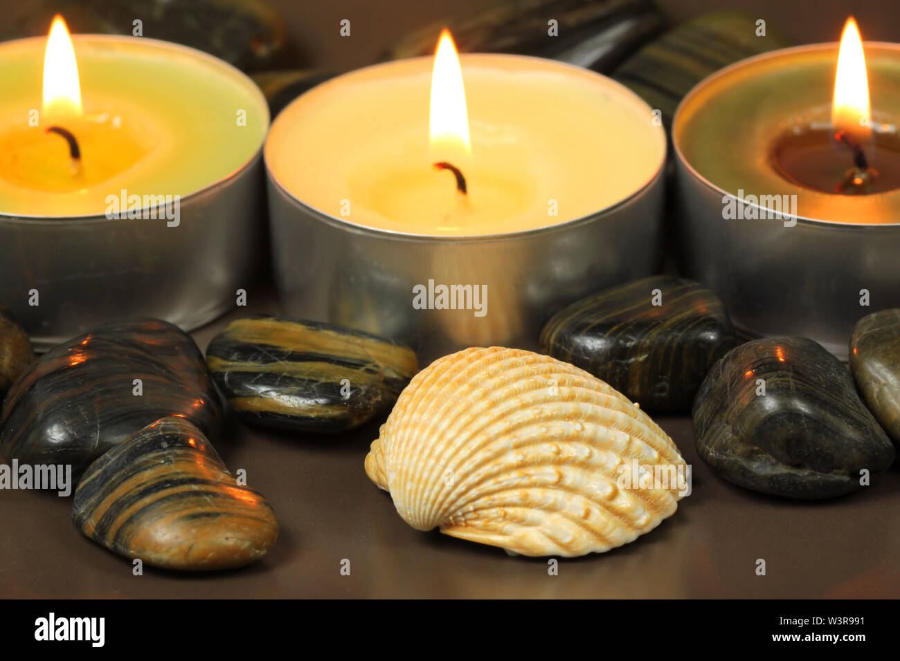 Spa still life. Guilhemroux avec massage stones et brûler des bougies. Lumière tamisée Banque D'Images