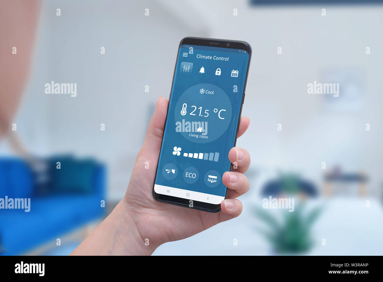 Contrôle climatique moderne de l'interface de l'application sur un smartphone dans la main. Concept de régulation de température simple et automatique du chauffage. Banque D'Images