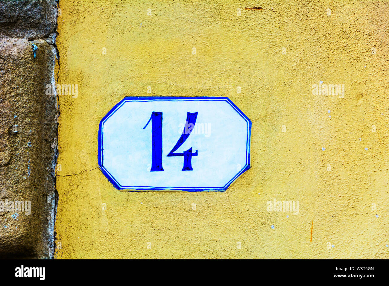 Numéro de maison quatorze ( 14 ) sur un mur crépi Banque D'Images