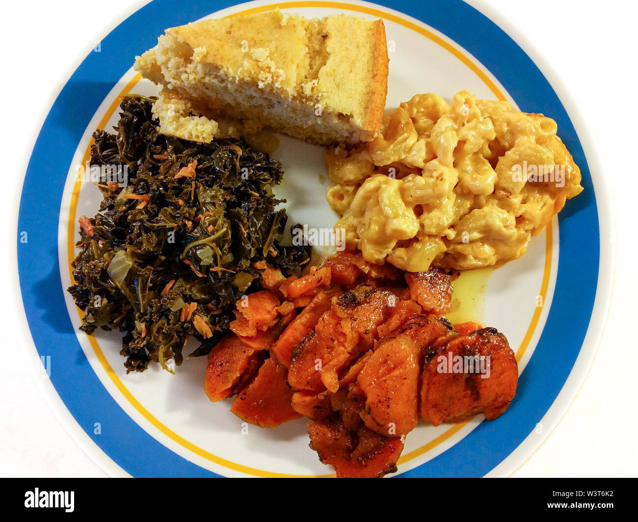 Une plaque de southern comfort food en Amérique. Une portion de greens kale, confit d'ignames, des macaronis au fromage et cornbread. Vue d'en haut. Banque D'Images