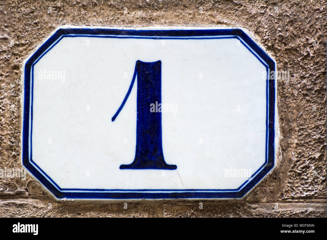 Numéro de maison une ( 1 ) sur un mur crépi Banque D'Images