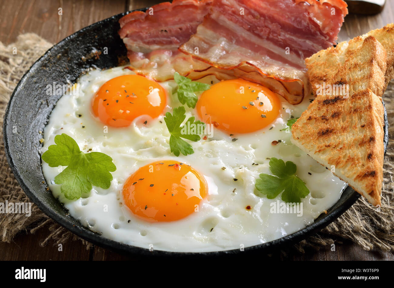 Les œufs au plat, du bacon et des toasts sur poêle, vue en gros Banque D'Images