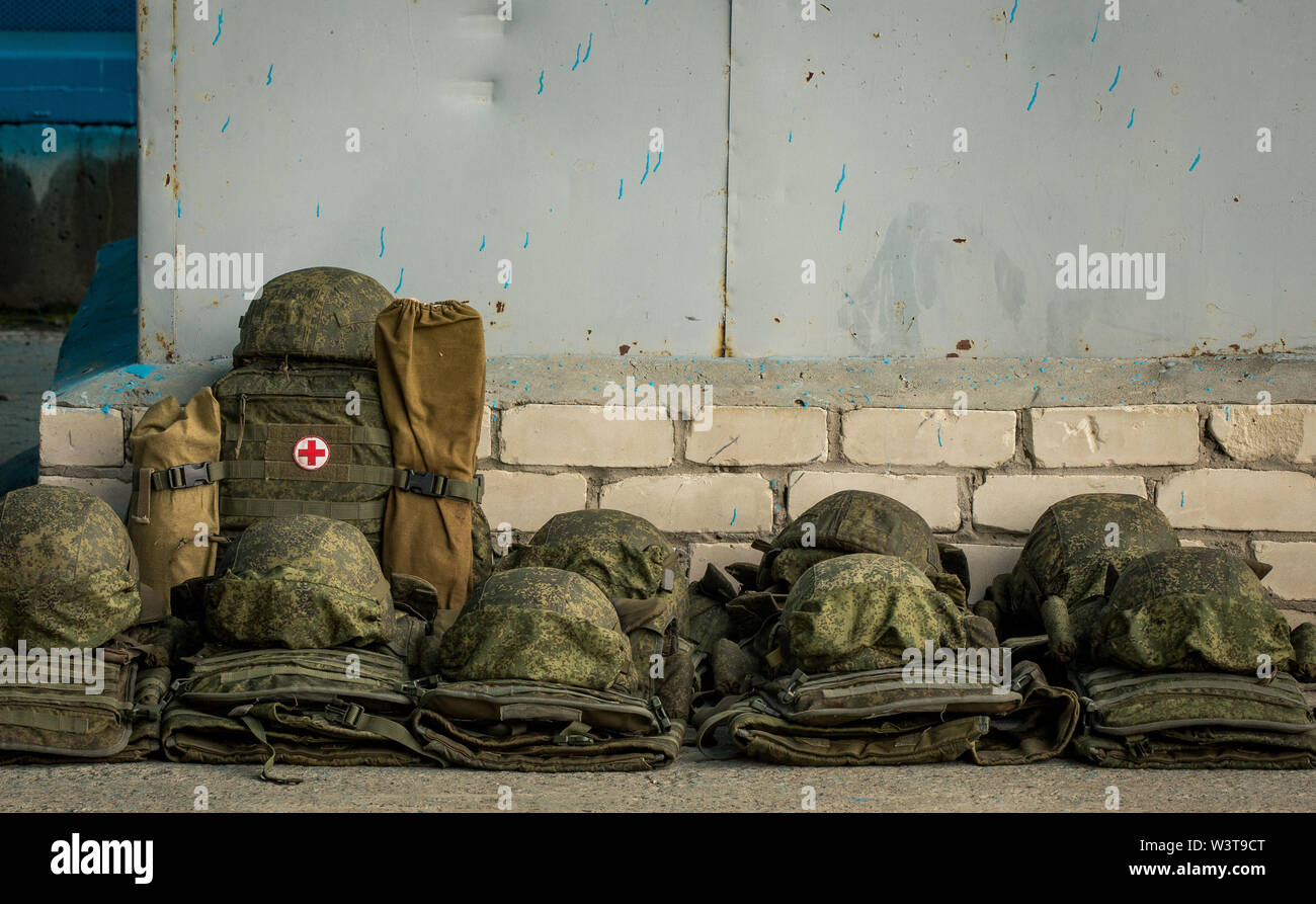 Les casques de l'armée se trouvent dans une rangée sur l'asphalte à côté de la trousse de premiers soins. Ambulance Banque D'Images