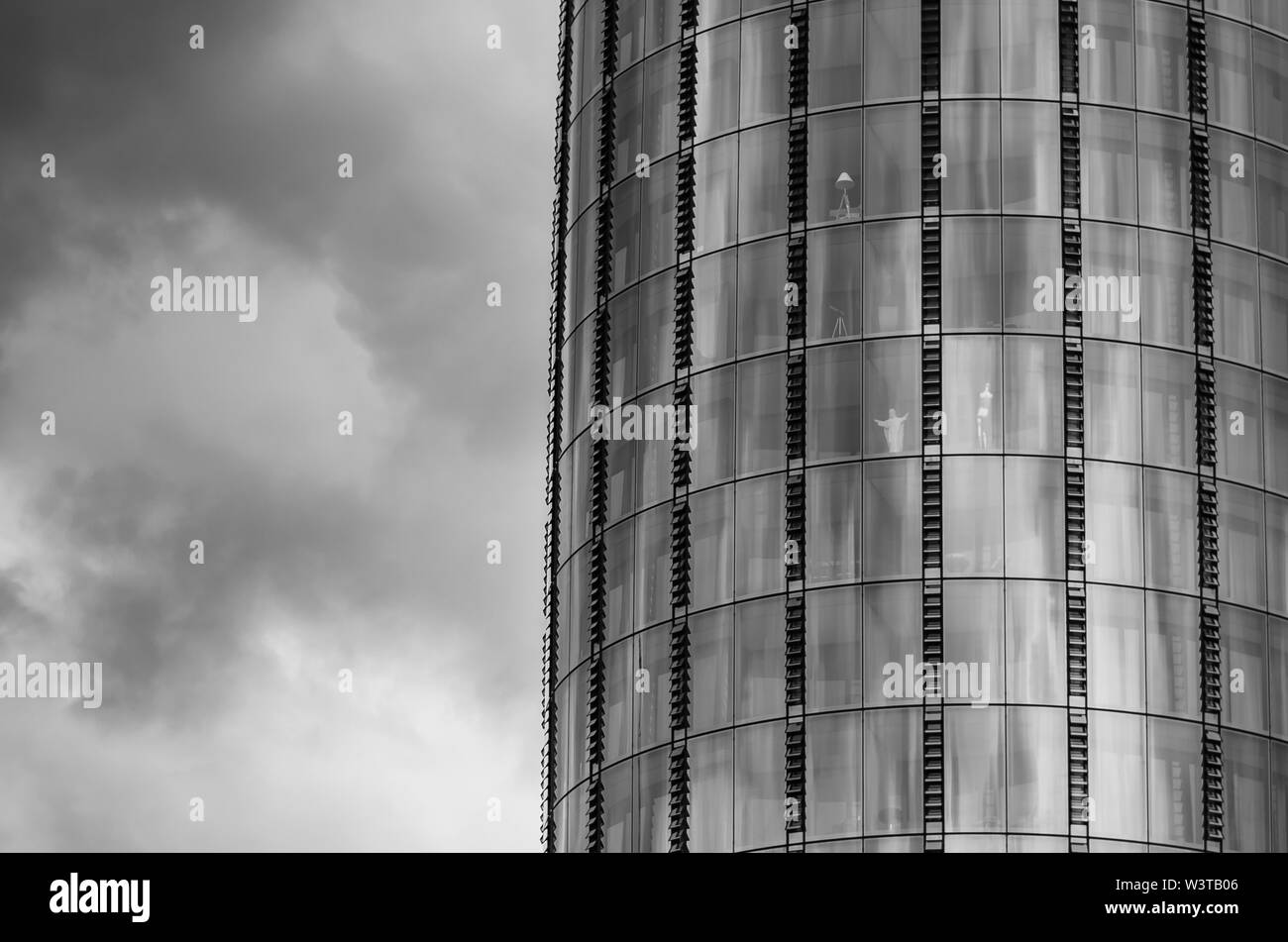 Photo en noir et blanc de la gratte-ciel et un ciel dramatique quelque part à Londres. La statue de miniature Brasil Jésus Christ est vu dans l'un des w Banque D'Images