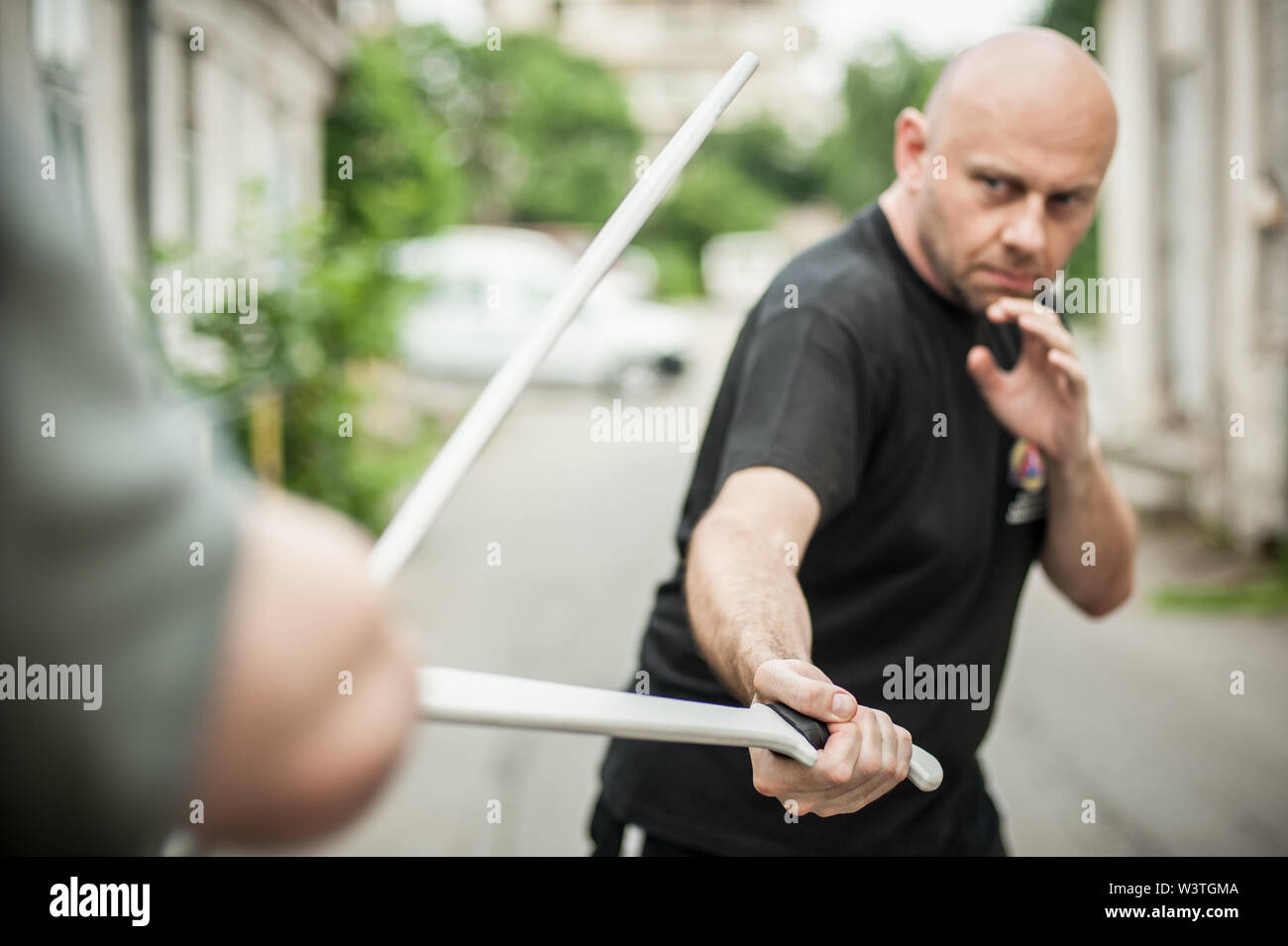 L'Eskrima et wushu démontre l'instructeur technique de combat à la machette avec son élève. Long Couteau arme de la formation. Démonstration avec l'épée en plastique Banque D'Images
