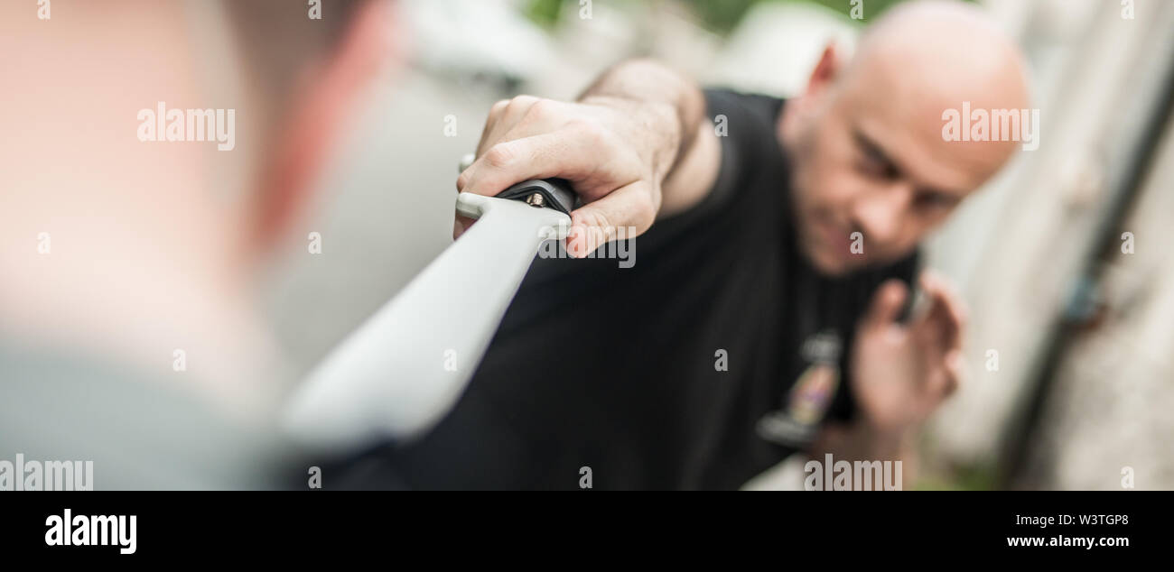 L'Eskrima et wushu démontre l'instructeur technique de combat à la machette avec son élève. Long Couteau arme de la formation. Démonstration avec l'épée en plastique Banque D'Images
