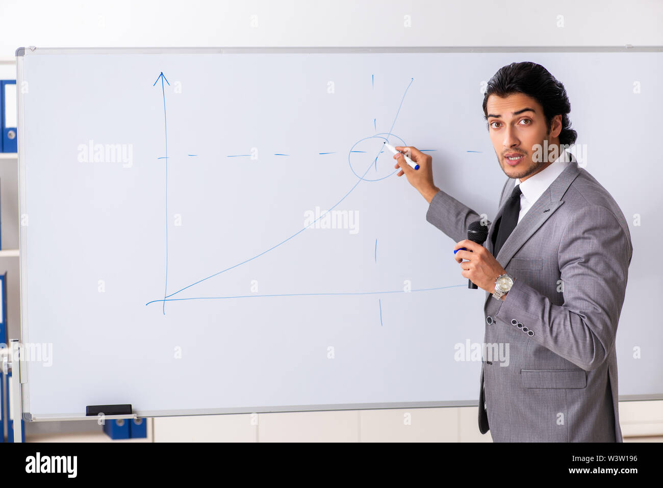 Theyoung handsome businessman in front of whiteboard Banque D'Images