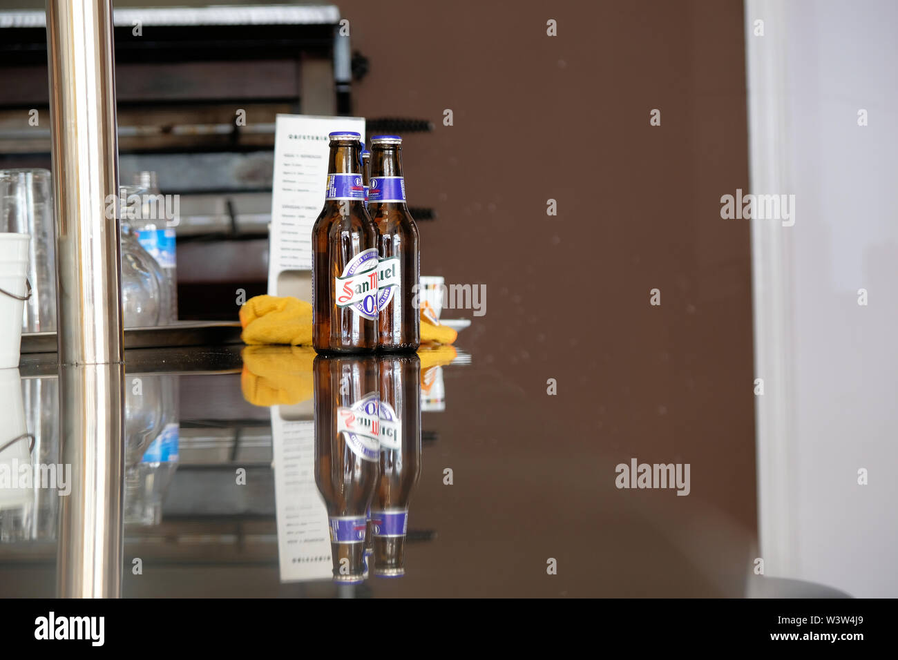 Deux bouteilles de San Miguel 0,0 sans alcool bière Pilsen sur un restaurant bar comptoir avec leur propre reflet, Granada, Espagne. Banque D'Images