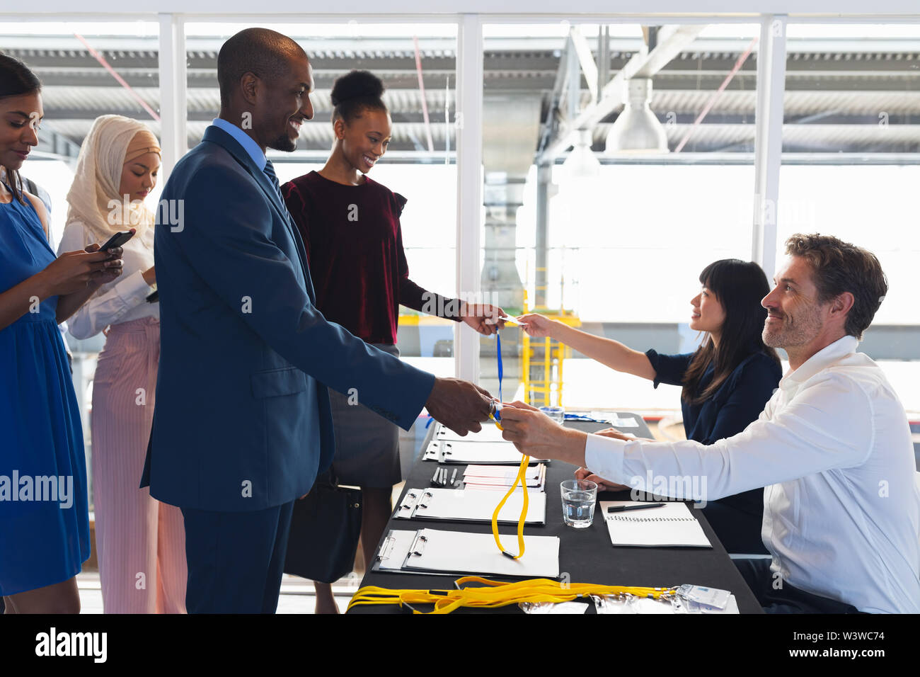 Les gens d'affaires de l'enregistrement à la table d'inscription à la conférence Banque D'Images