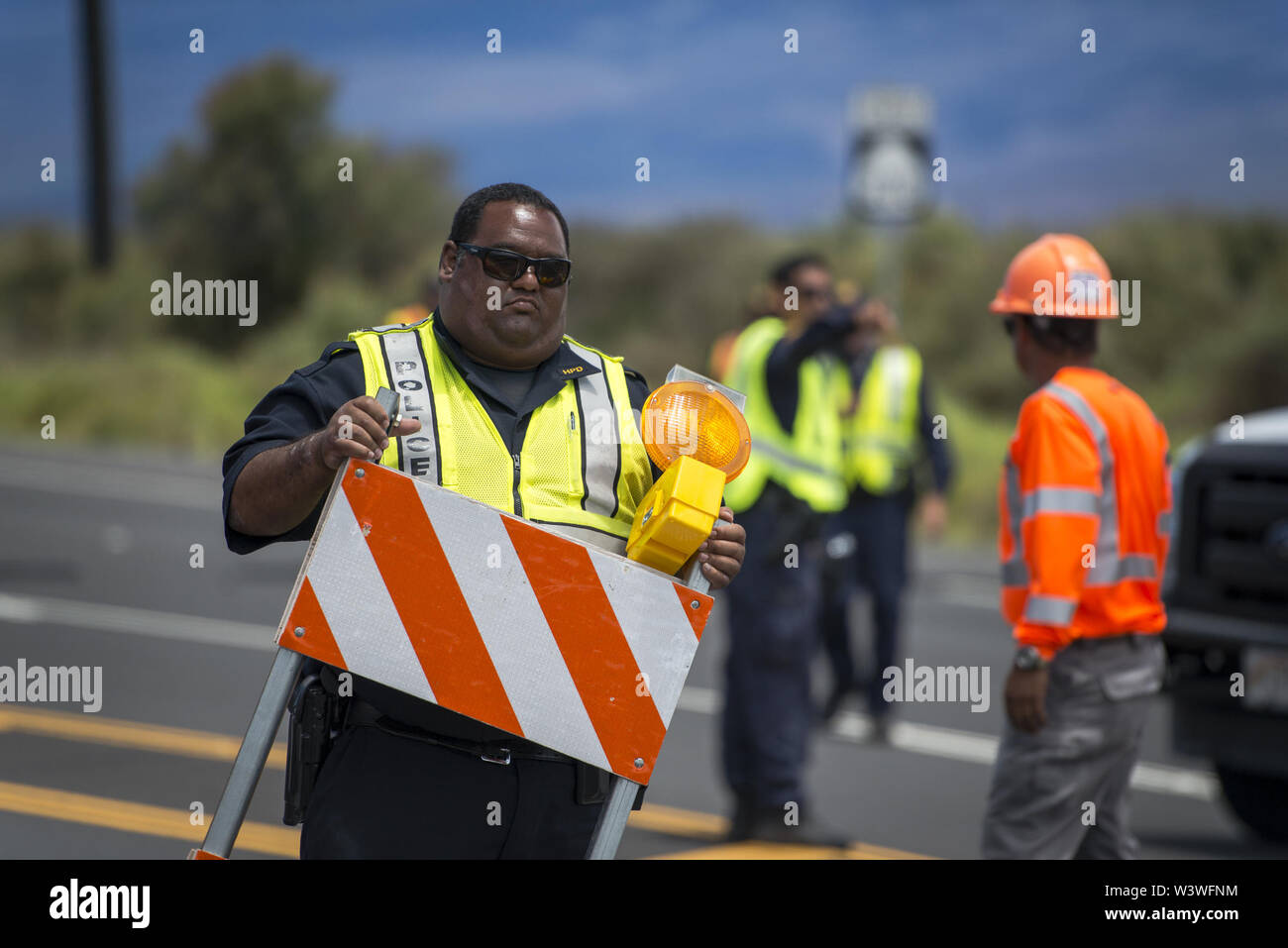 Mauna Kea, Hawaii, USA. 17 juillet, 2019. La police et les employés de l'Hawaii Island Ministère des Transports homme Barrages limitant l'accès à la route d'accès de Mauna Kea, le site des manifestations en réponse à la construction d'un télescope massive de terres que beaucoup considèrent les autochtones hawaiiens sacré. Credit : Ronit Fahl/ZUMA/Alamy Fil Live News Banque D'Images