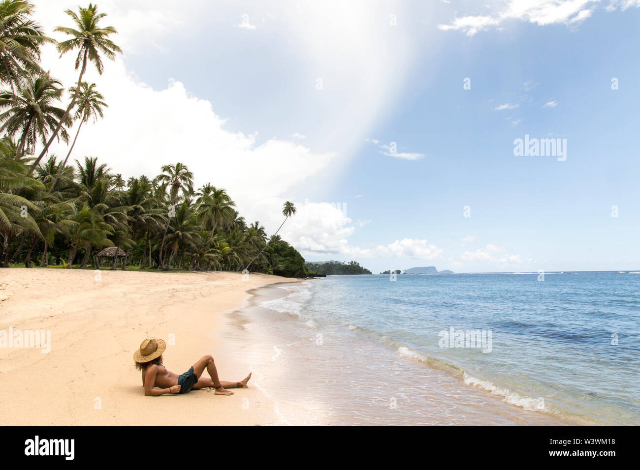 L'homme, portant chapeau de paille, le bronzage sur une plage de sable doré, le Samoa Banque D'Images
