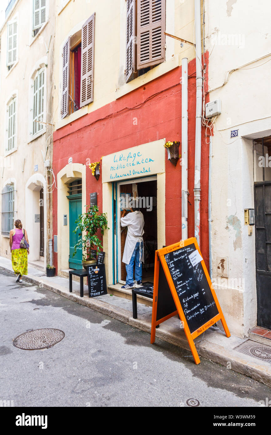 Marseille, France - 8 septembre 2015 : une femme passe devant un petit restaurant,. Le quartier du Vieux Port a beaucoup de vieux bâtiments. Banque D'Images