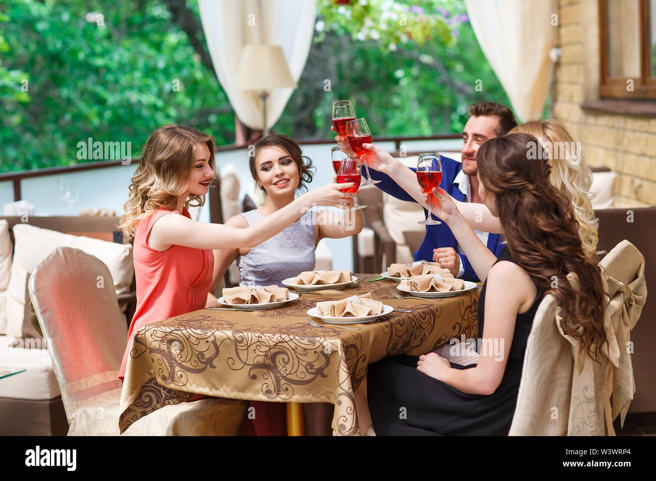 Les amis de boire du vin sur la terrasse en été. Banque D'Images