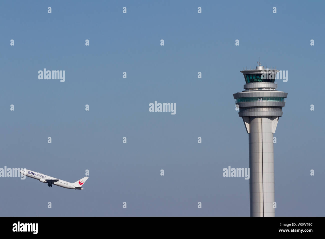 Un Boeing 767-300, en livrée One World, de Japan Airlines (JAL) décolle derrière la tour de contrôle de l'aéroport international Haneda, Tokyo, Japon. Banque D'Images